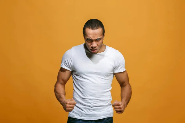 O jovem homem irritado emocional gritando no fundo do estúdio laranja — Fotografia de Stock