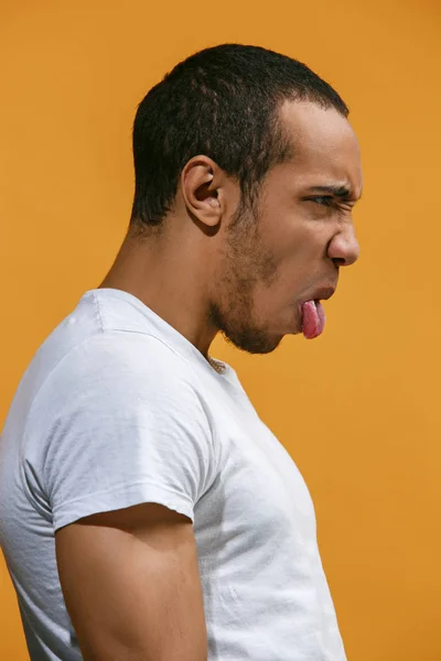 狂気のアフリカ系アメリカ人男性はオレンジ色の背景に対して面白い見ています。 — ストック写真