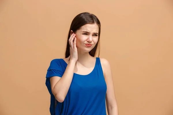 A dor de ouvido. A mulher triste com dor de cabeça ou dor em um fundo de estúdio pastel . — Fotografia de Stock