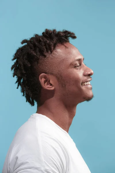 O homem afro-americano de negócios feliz de pé e sorrindo contra o fundo azul. Vista do perfil . — Fotografia de Stock