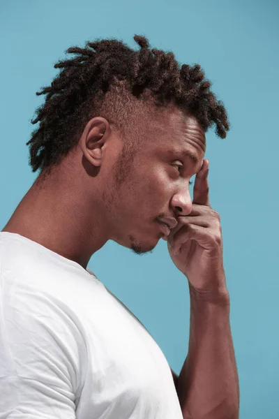 Déjeme pensar. Dudable hombre afro-americano pensativo con expresión reflexiva haciendo elección contra fondo azul —  Fotos de Stock