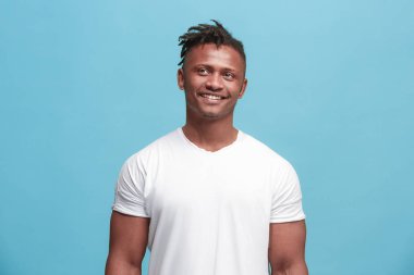 Ayakta ve mavi arka planı gülümseyen mutlu Afro-Amerikan iş adamı.