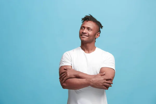 Щасливий бізнес афроамериканський чоловік стоїть і посміхається на синьому фоні . — стокове фото