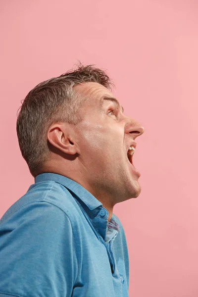 O jovem homem irritado emocional gritando no fundo do estúdio rosa — Fotografia de Stock