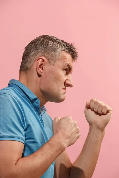 O jovem homem irritado emocional gritando no fundo do estúdio rosa — Fotografia de Stock