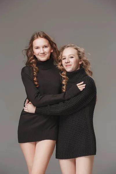 Dziewczyny moda razem stojąc i patrząc na kamery przez studio szary tło — Zdjęcie stockowe
