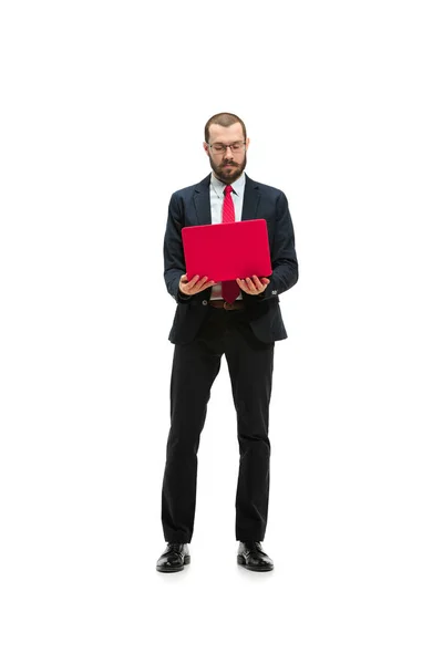 Immagine di bel giovane uomo barbuto in piedi sopra lo sfondo bianco studio con computer portatile — Foto Stock