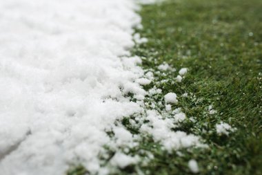 Toplantı beyaz kar ve yeşil çim yakın - kış ve bahar arasında kavramı arka plan. Bahar hakkında kavramsal görüntü. Seçici odak. Arka plan kopya alanı ile