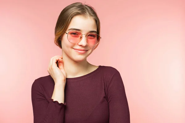 Woman smiling with perfect smile and white teeth on the pink studio background and looking at camera — Stock Photo, Image