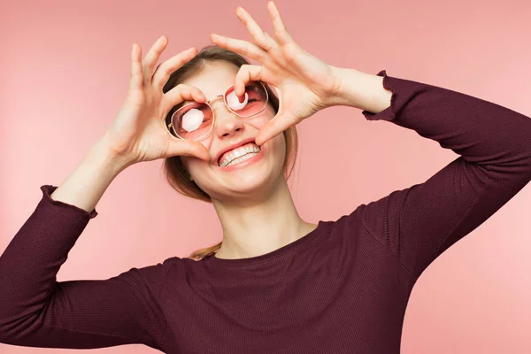 Kvinnan ler med perfekt leende och vita tänder på rosa studio bakgrunden. — Stockfoto