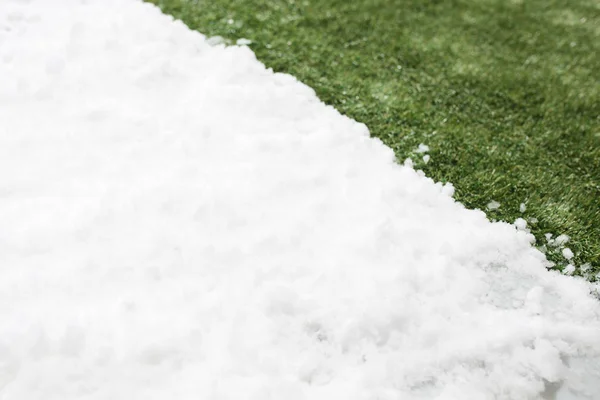 Incontro neve su erba verde da vicino - tra inverno e primavera concetto di sfondo — Foto Stock