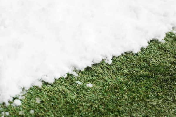 Incontro neve su erba verde da vicino - tra inverno e primavera concetto di sfondo — Foto Stock