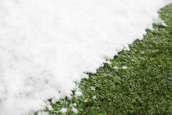 Incontro neve su erba verde da vicino - tra inverno e primavera concetto di sfondo — Foto Stock
