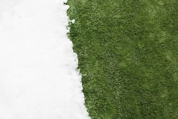 Incontro neve su erba verde da vicino - tra inverno e primavera concetto di sfondo — Foto Stock