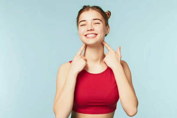 Mulher sorrindo com sorriso perfeito no fundo do estúdio azul — Fotografia de Stock