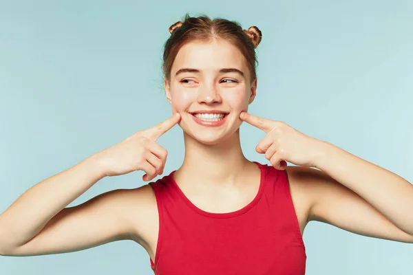 Mujer sonriendo con una sonrisa perfecta en el fondo azul del estudio — Foto de Stock