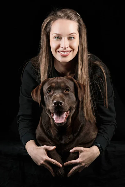 A jovem mulher abraçando um cão de raça de mistura — Fotografia de Stock