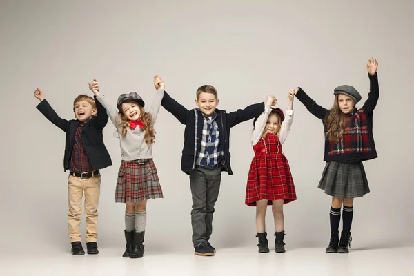 Die Gruppe schöner Mädchen und Jungen auf pastellfarbenem Hintergrund — Stockfoto