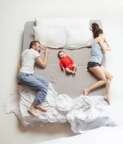 Widok z góry szczęśliwe rodziny z jednym dzieckiem noworodka w sypialni. — Zdjęcie stockowe