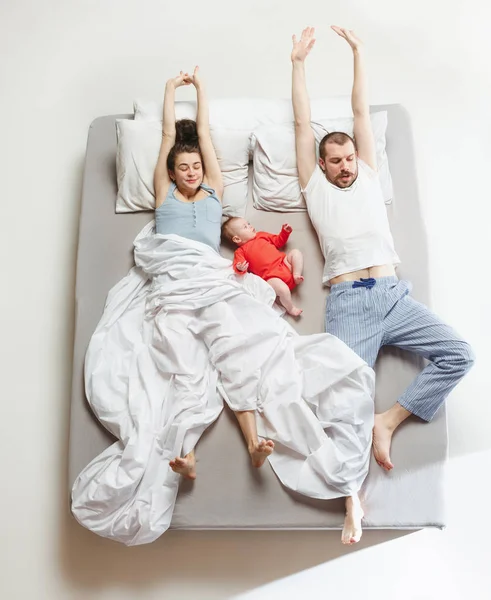 Pandangan atas keluarga bahagia dengan satu anak yang baru lahir di kamar tidur . — Stok Foto