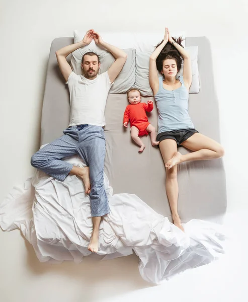 Top view of happy family with one newborn child in bedroom.