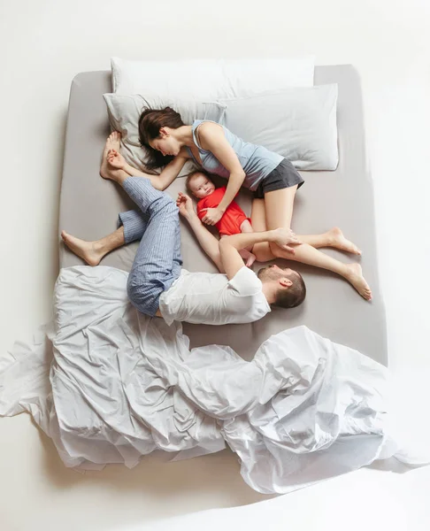 Vista dall'alto della famiglia felice con un neonato in camera da letto . — Foto Stock