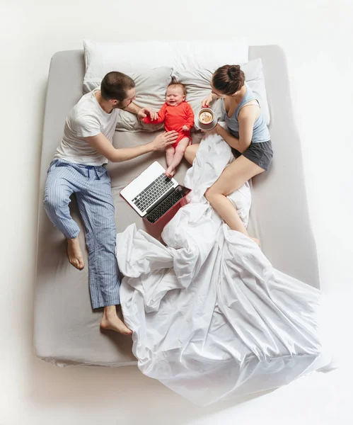 Pohled shora šťastná rodina s jedním dítětem novorozence v ložnici. — Stock fotografie
