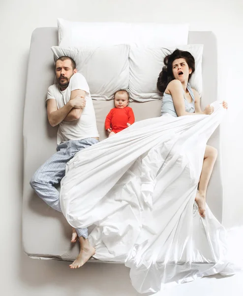 Top view of happy family with one newborn child in bedroom.