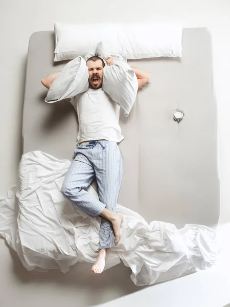 Vista superior de la foto de un hombre joven durmiendo en una gran cama blanca —  Fotos de Stock