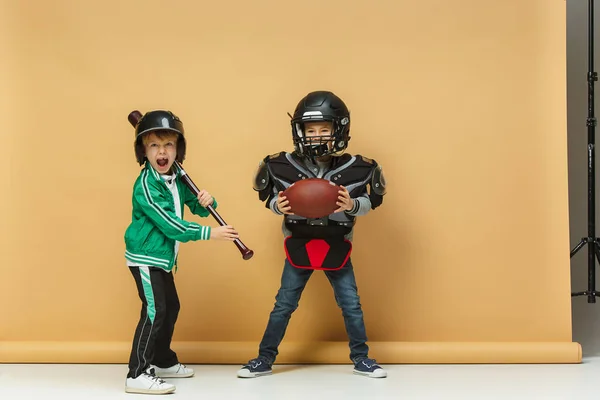 Två glada barn Visa olika sport. Studio fashion-konceptet. Känslor-konceptet. — Stockfoto