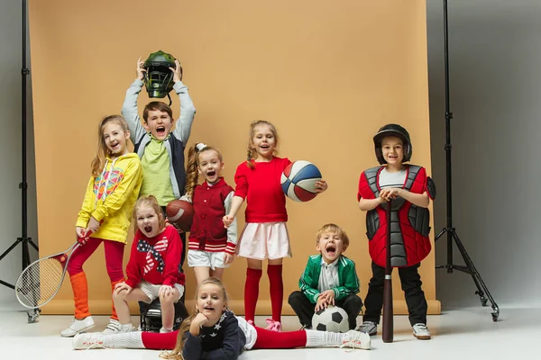 Group of happy children show different sport. Studio fashion concept. Emotions concept.