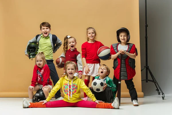 Boldog gyermekek csoportja megjelenítése különböző sport. Stúdió divat fogalmát. Érzelmek fogalma. — Stock Fotó