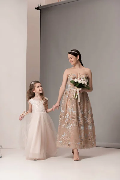 Little pretty girls with flowers dressed in wedding dresses — Stock Photo, Image