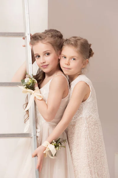Kleine hübsche Mädchen mit Blumen in Brautkleidern — Stockfoto