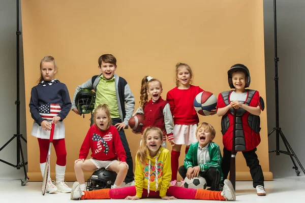 Group of happy children show different sport. Studio fashion concept. Emotions concept. Royalty Free Stock Images