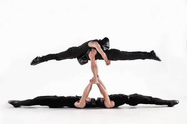 O grupo de homens caucasianos acrobáticos de ginástica em pose de equilíbrio — Fotografia de Stock