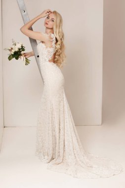 Gelin kapalı beyaz studio iç gibi evde duran güzel elbiseli. Moda düğün tarzı vurdu. Genç çekici beyaz model bir gelin gibi ihale arıyorsunuz.