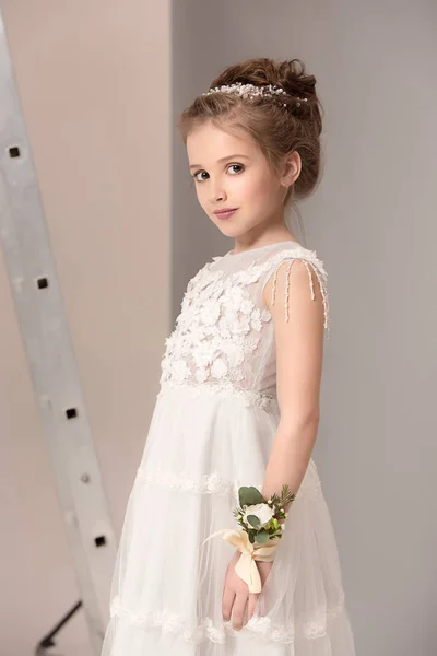 花と小さなかわいい女の子はウェディング ドレスに身を包んだ — ストック写真