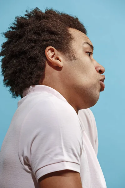 Belo retrato masculino de meia-duração isolado em backgroud estúdio azul. O jovem emotivo surpreendido homem — Fotografia de Stock