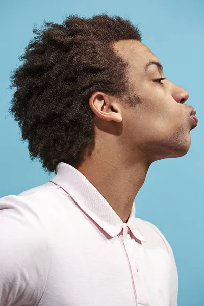 Mavi arka plan üzerinde izole öpücükle çekici afro adam portresi