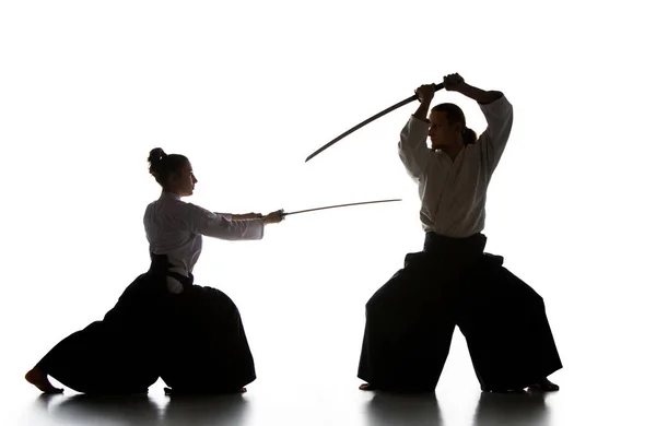 Hombre y mujer luchando y entrenando aikido en fondo blanco estudio — Foto de Stock