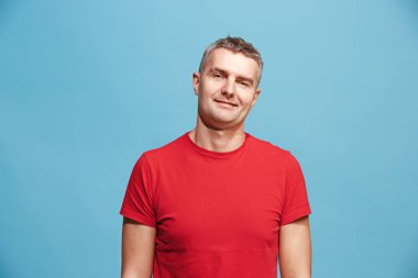 Ayakta ve mavi arka planı gülümseyen mutlu iş adamı.