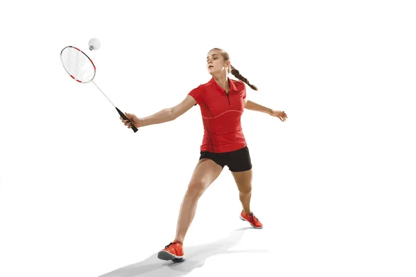 Genç kadın beyaz arka plan üzerinde badminton oynarken — Stok fotoğraf