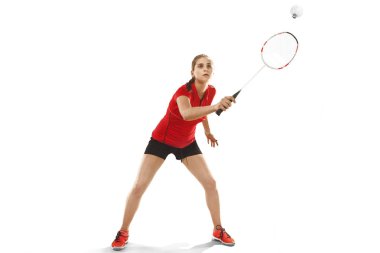 Genç kadın beyaz arka plan üzerinde badminton oynarken