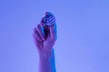 Erkek el ile mavi zemin üzerine altın Litecoin