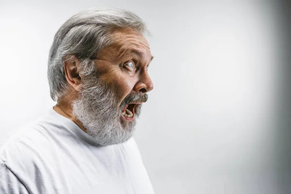 Ο ανώτερος συναισθηματική θυμωμένος άνθρωπος ουρλιάζοντας σε φόντο λευκό στούντιο — Φωτογραφία Αρχείου