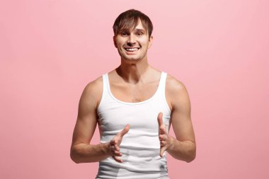 Mutlu adam ayakta ve pembe arka plan üzerinde gülümseyen.