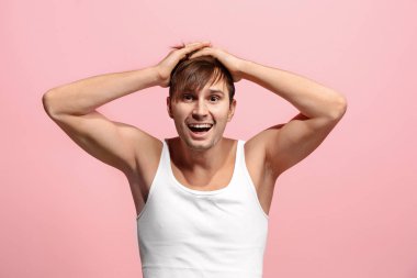 Mutlu adam ayakta ve pembe arka plan üzerinde gülümseyen.