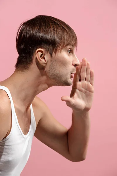 Isoliert auf rosa jungen lässigen Mann schreit im Studio — Stockfoto