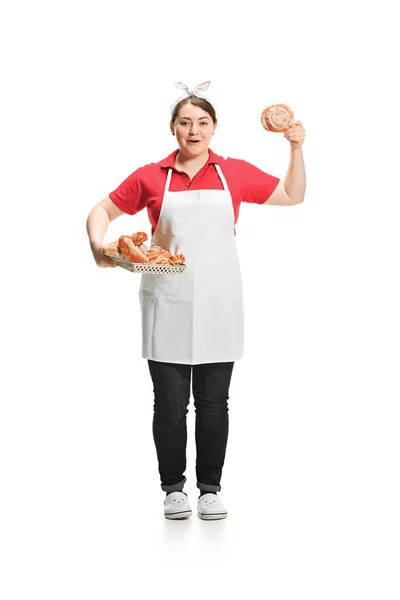 Portrait de mignonne femme souriante avec des pâtisseries dans ses mains en studio, isolée sur fond blanc — Photo